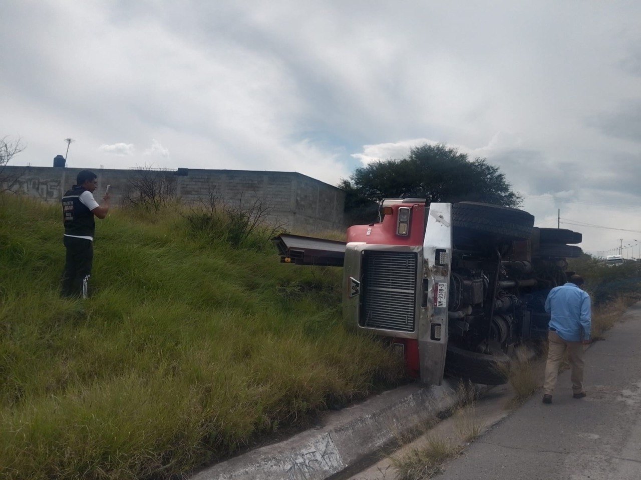 Tráiler queda volcado fuera de la vialidad y genera caos por curiosos en el Surponiente